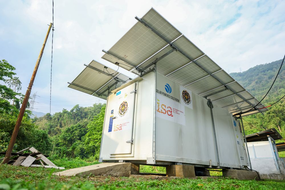The white cold room under its solar panel canopy, marked with the ISA and Royal Government of Bhutan logos