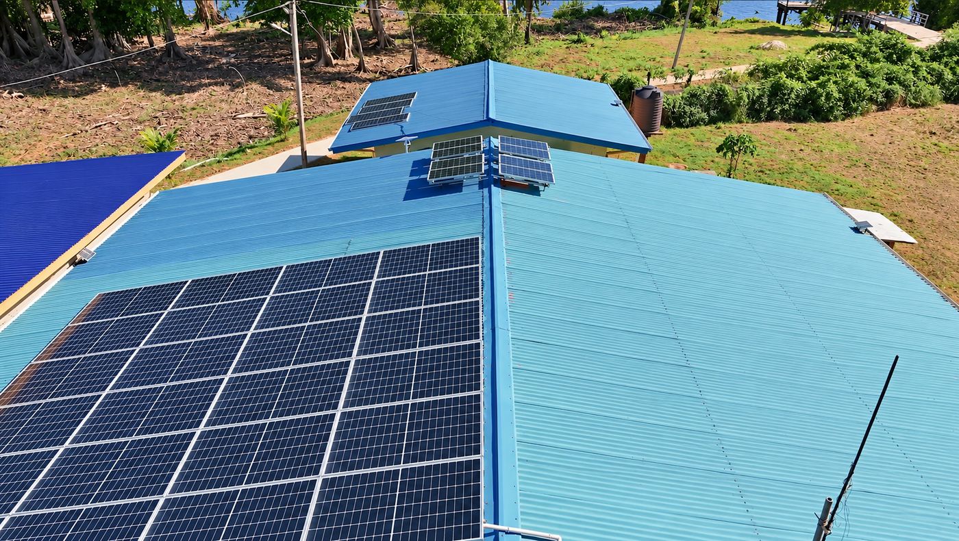 Solar panels mounted on the blue metal roof of the Orealla Health Centre