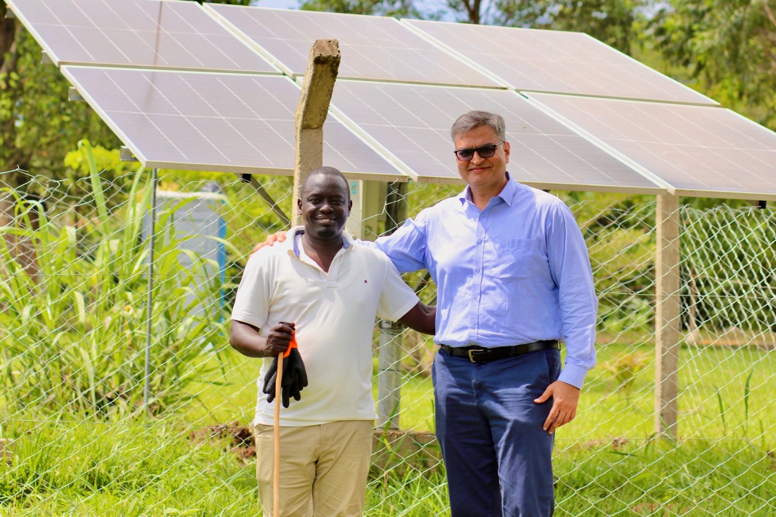 Gaddafi Nassour and ISA’s Director General standing in front of a solar panel array